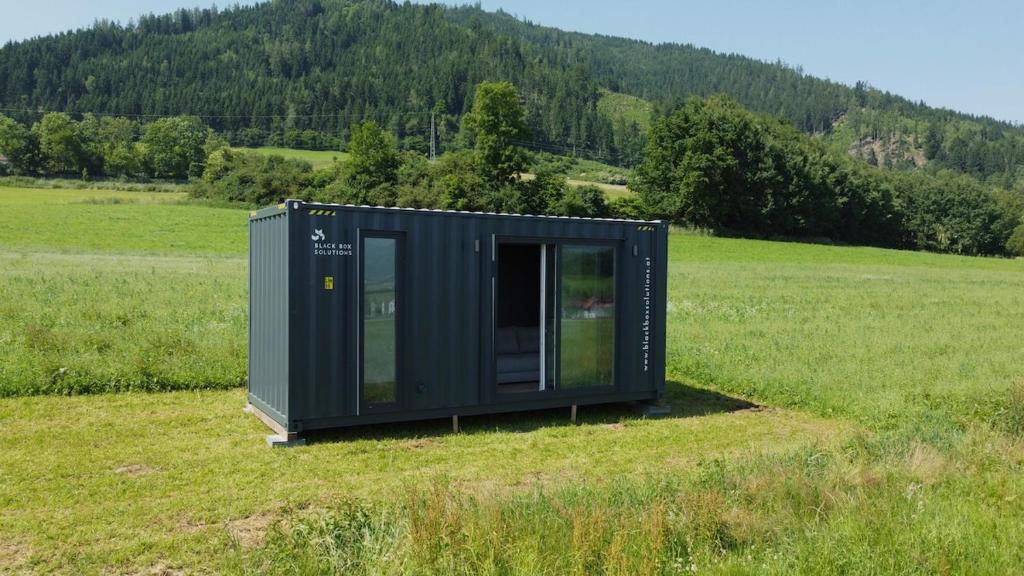 a green tiny house sitting in a field at Tinyhome Murtal -SlowCamping in Fohnsdorf