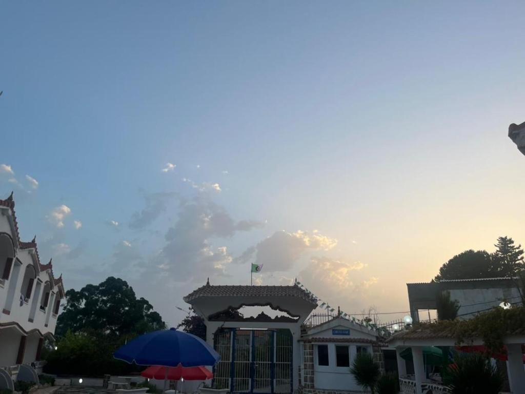 two umbrellas sitting in front of a building at Résidence île des Pisans Nezla in Bejaïa