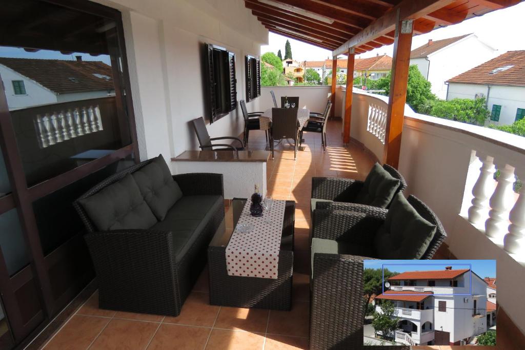 uma varanda com sofás, uma mesa e cadeiras em Apartments Gloria em Biograd na Moru