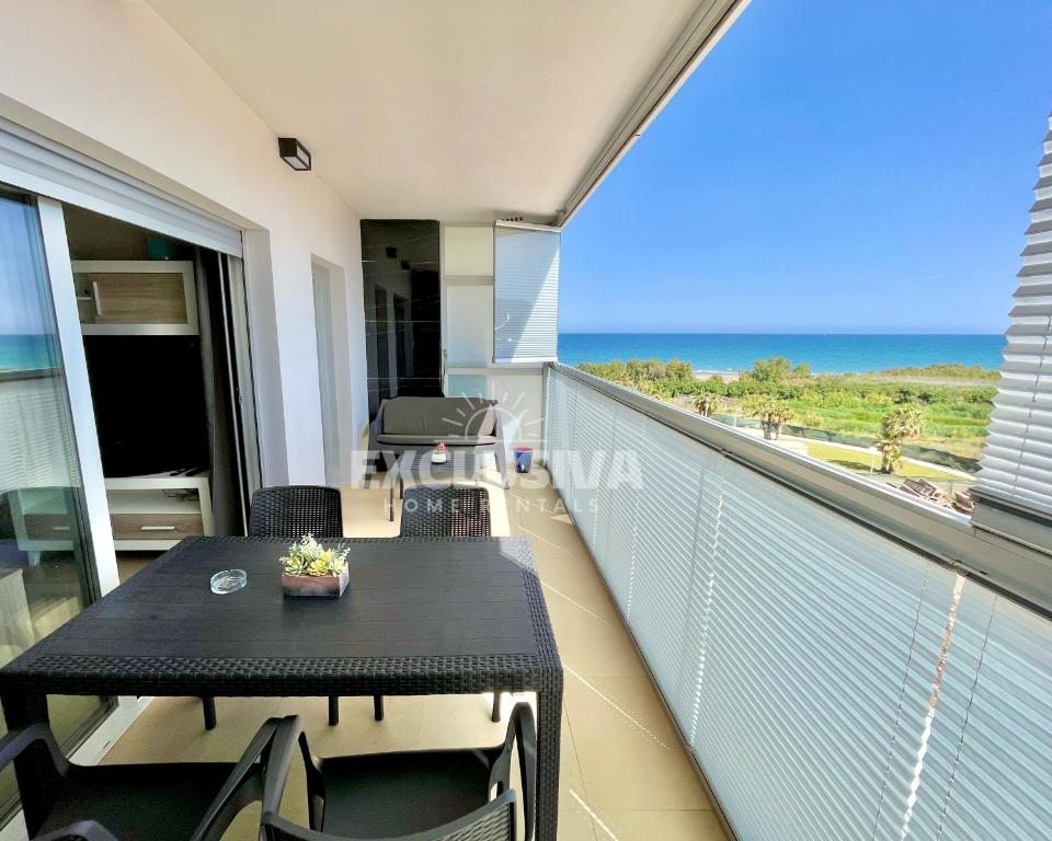 a balcony with a table and a view of the ocean at Perla Home, 1ªLínea, Magic World in El Borseral