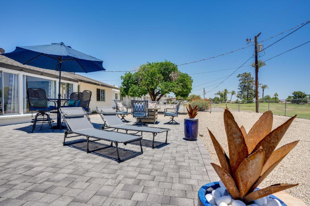 a group of chairs and an umbrella on a patio at 5 Mi to State Farm Stadium Sun City Retreat in Sun City
