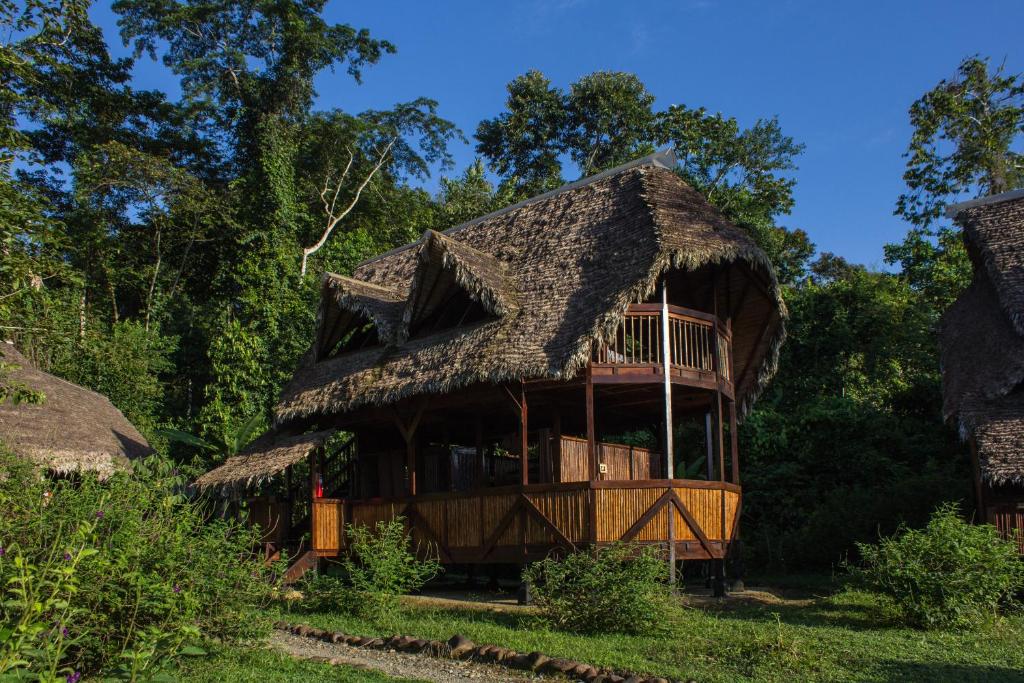 a bamboo house with a thatched roof at Ecotone Manu Learning Center, All-Inclusive in Pillcopata