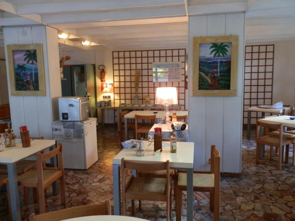 マリーナ・ロメアにあるHotel Antilleのテーブルと椅子のあるレストラン、キッチンが備わります。