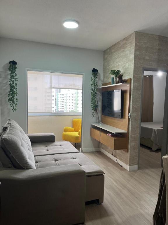 un salon avec un canapé et une télévision dans l'établissement Apartamento em Vila Velha, à Vila Velha