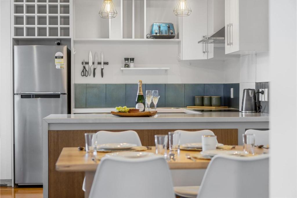 Una cocina con gabinetes blancos y una mesa y sillas. en D-Street Retreat - Hamilton, en Hamilton