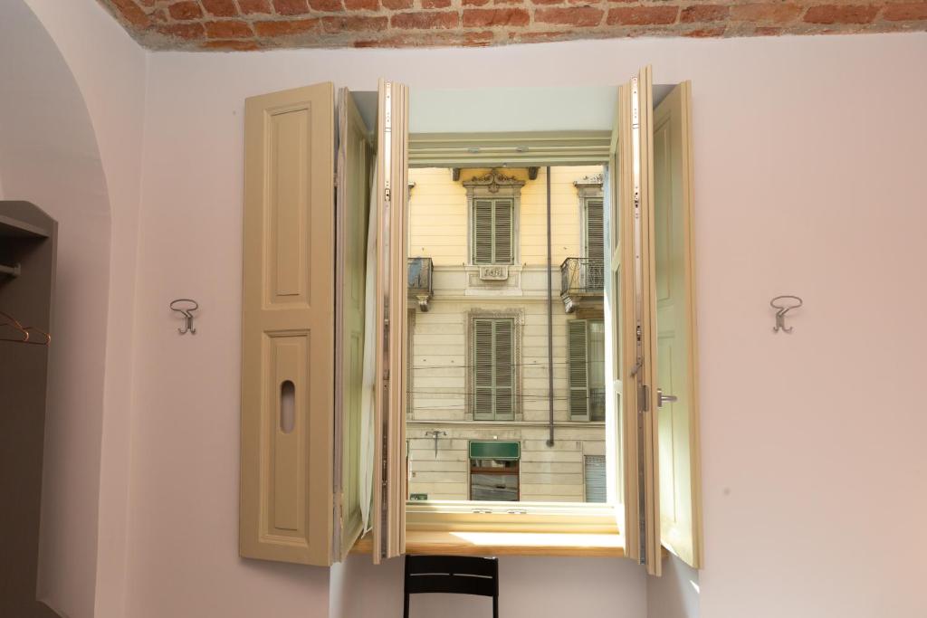 Una ventana abierta con un edificio afuera. en B&B Torino Arcuri, en Turín