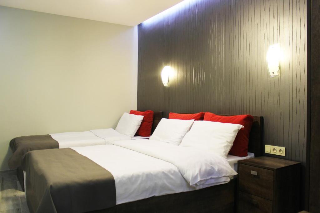 1 dormitorio con 1 cama grande con almohadas blancas y rojas en Studio rooms on the 2nd Floor, en Ereván