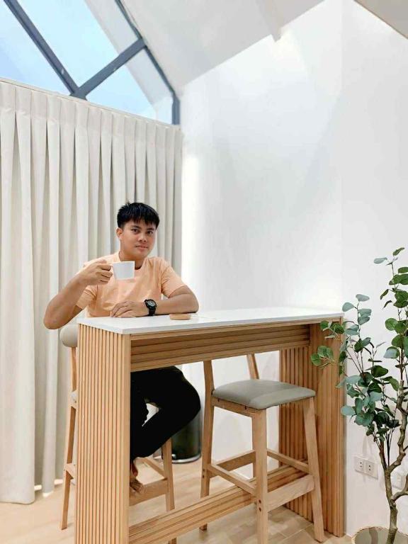 a man sitting at a table in a room at Yanis Resort in Calatagan