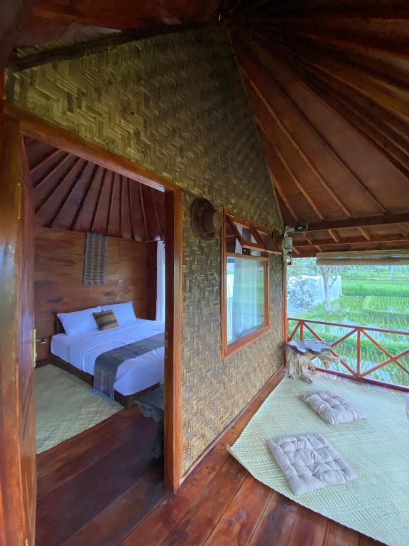 an inside view of a bedroom with a bed at Alang Cottage in Masbagik
