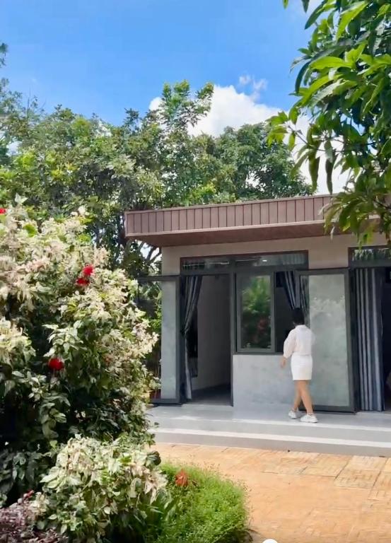 Buôn ÐũngHomestay Buôn Mê 4的一名女子站在一栋建筑物前