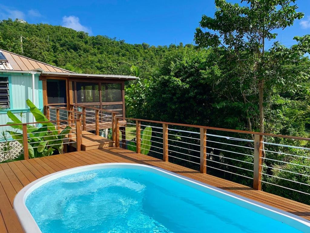 a swimming pool on a deck with a house at New Moon Escape - Affordable, Private Cottage with a Pool, WIFI and AC in Coral Bay
