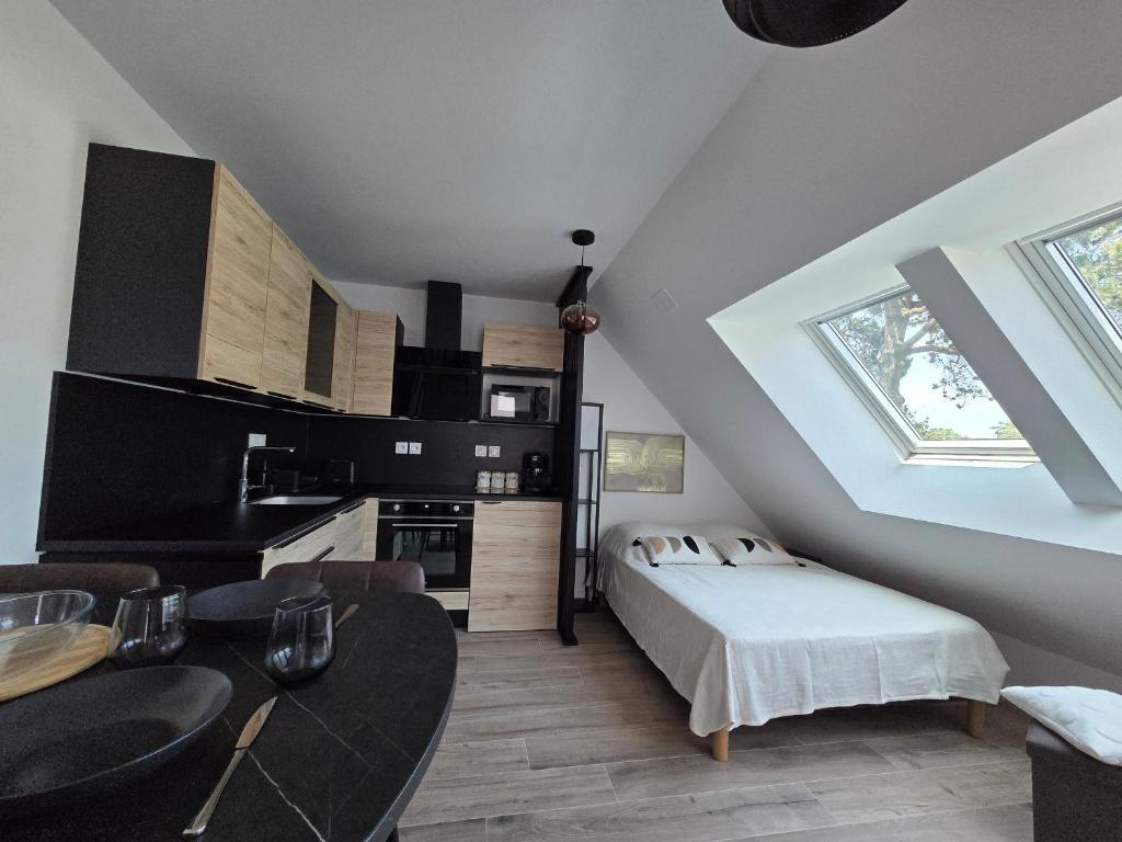 a attic room with a bed and a kitchen at Studio Neuf 23m² Proche Plage et Centre Tout Inclus - FR-1-364-183 in Saint-Brevin-les-Pins