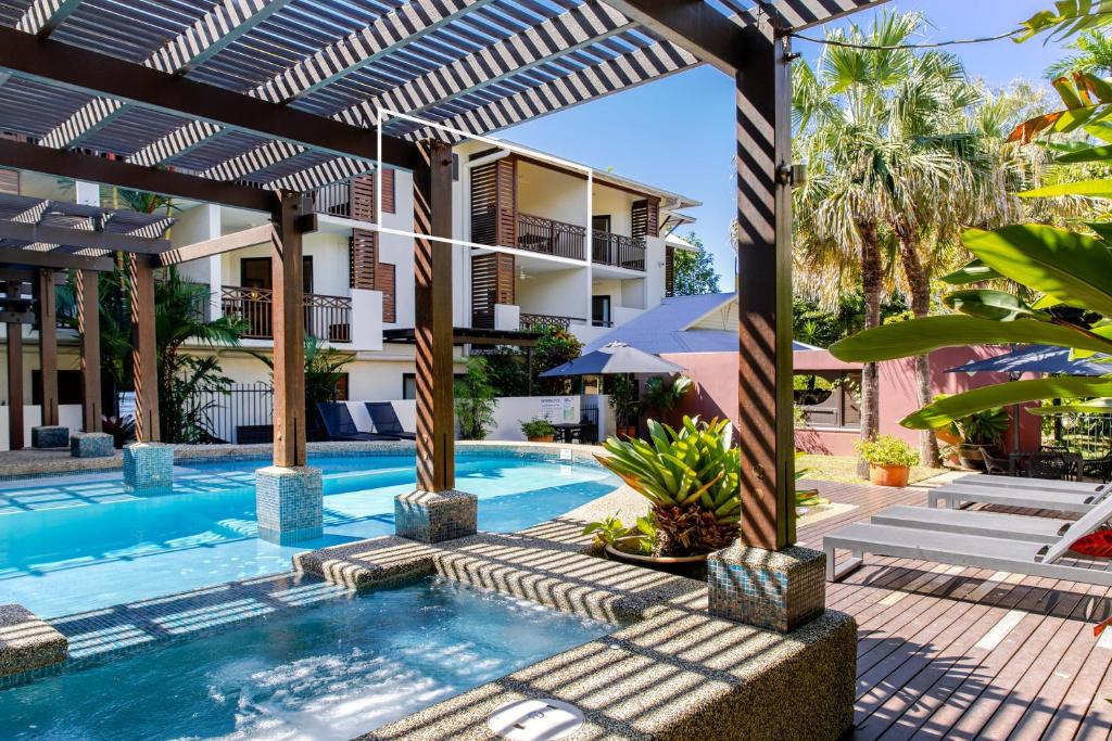 Una piscina al aire libre con pérgola y un complejo turístico. en 21 Freestyle Apartment with POOL VIEW, en Port Douglas