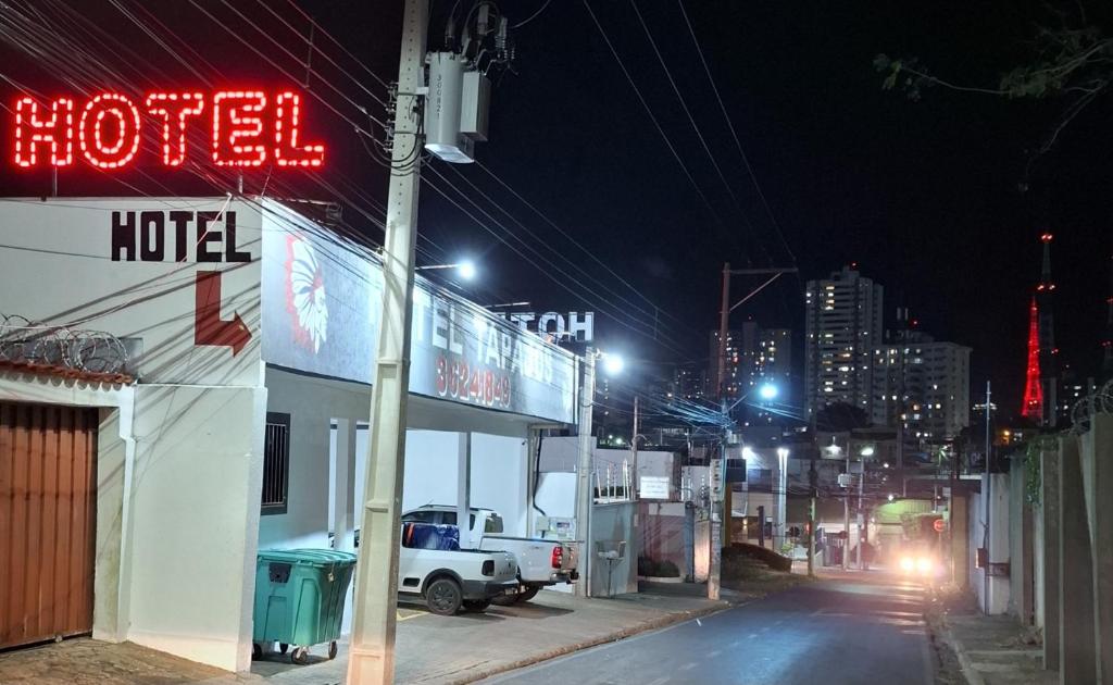 an empty street at night with a motel sign on a building at Hotel Tapajós in Cuiabá