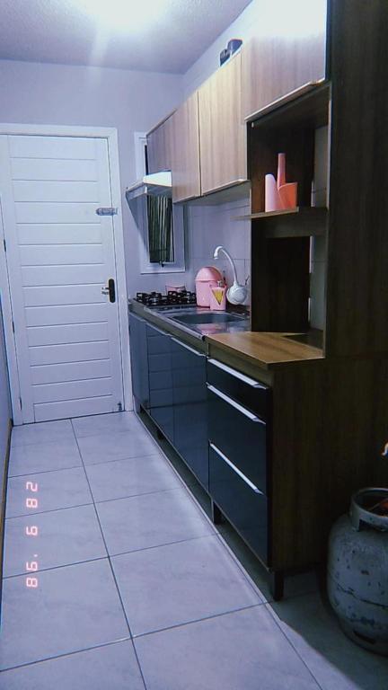 a kitchen with a counter and a stove top oven at Apartamento Mobiliado in Guaíba