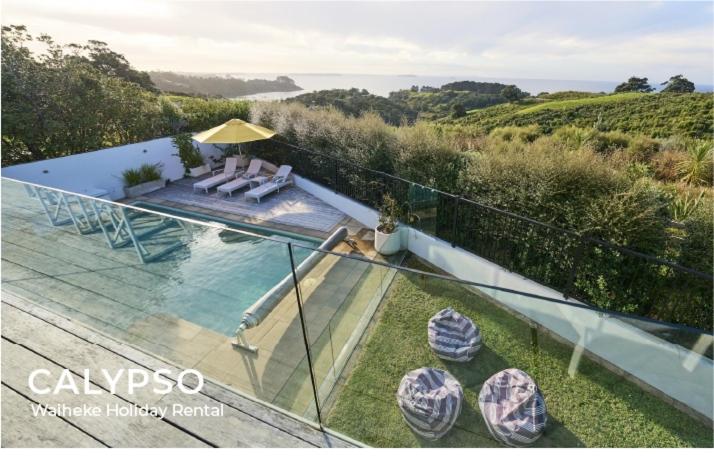 Waiheke IslandにあるCalypso -Waiheke island Villaの家のバルコニーからスイミングプールの景色を望めます。