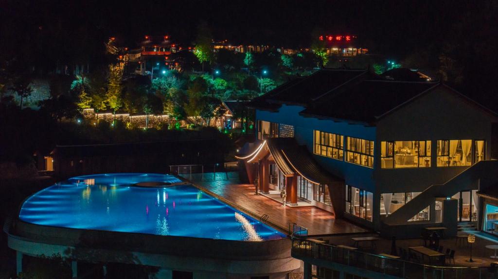 a large swimming pool in front of a building at night at Home Away from Home in Zhangjiajie