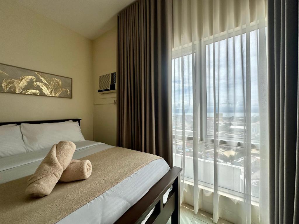 Un dormitorio con una cama y una ventana grande. en The Penthouse - 3BR Bi-Level Avida Aspira Tower 1, en Cagayan de Oro