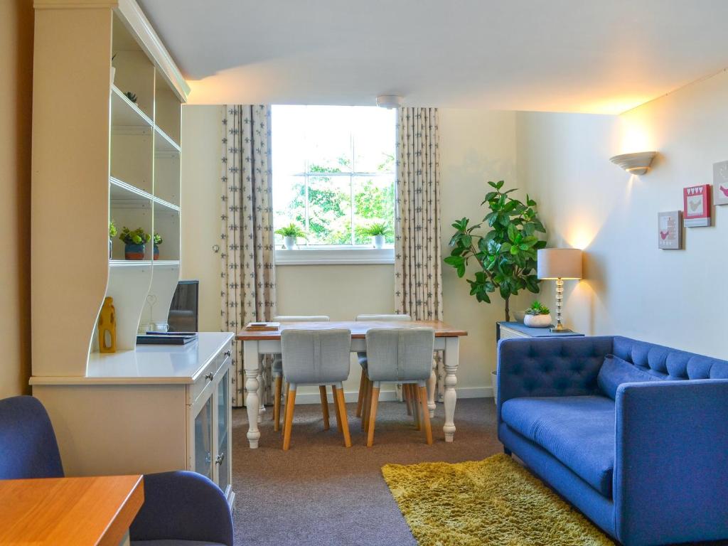 Una sala de estar con un sofá azul y una mesa. en County House Apartment - 27911, en York