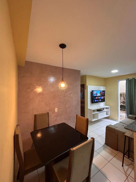 a living room with a table and a couch and a television at Apto Cop30 - Ideal BR - Completo in Ananindeua
