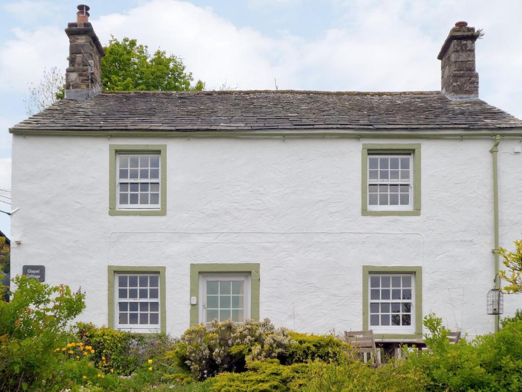 une maison blanche avec un toit dans l'établissement Chapel Cottage, à Askham