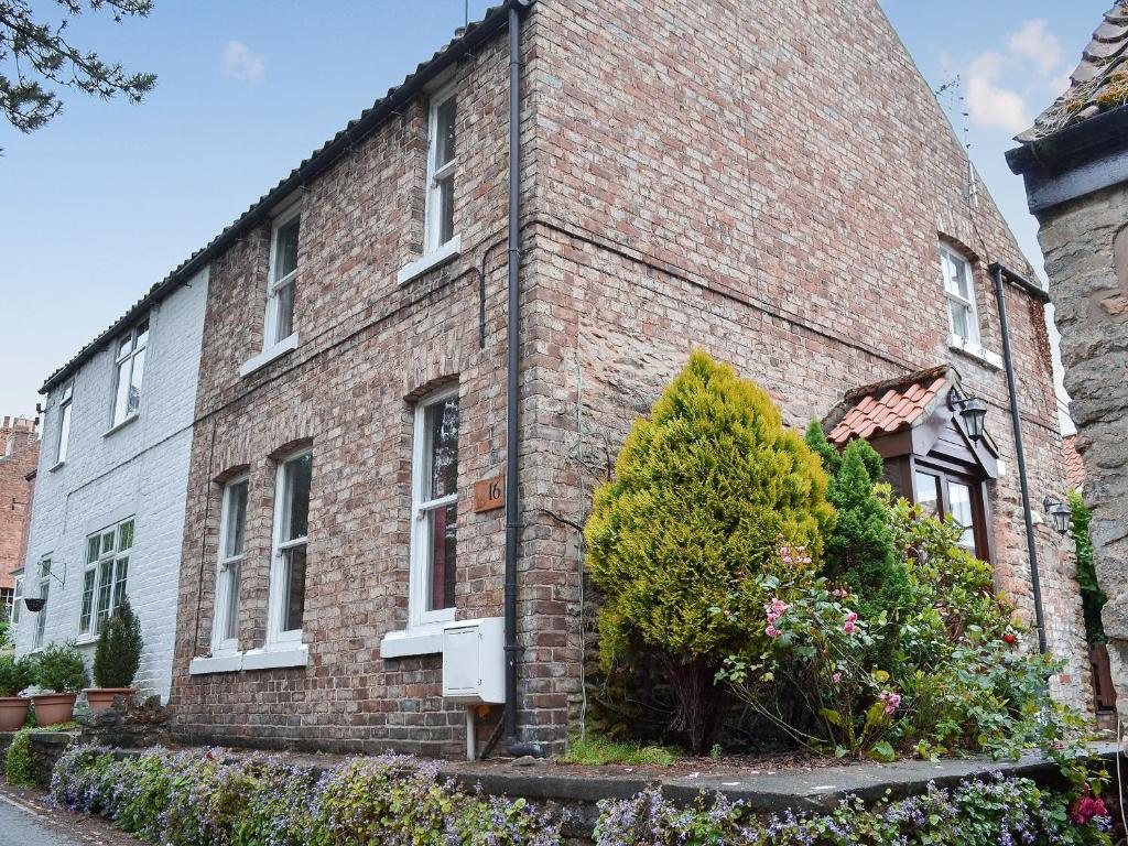 a brick building with a bush in front of it at Squirrel Cottage in Thornton Dale