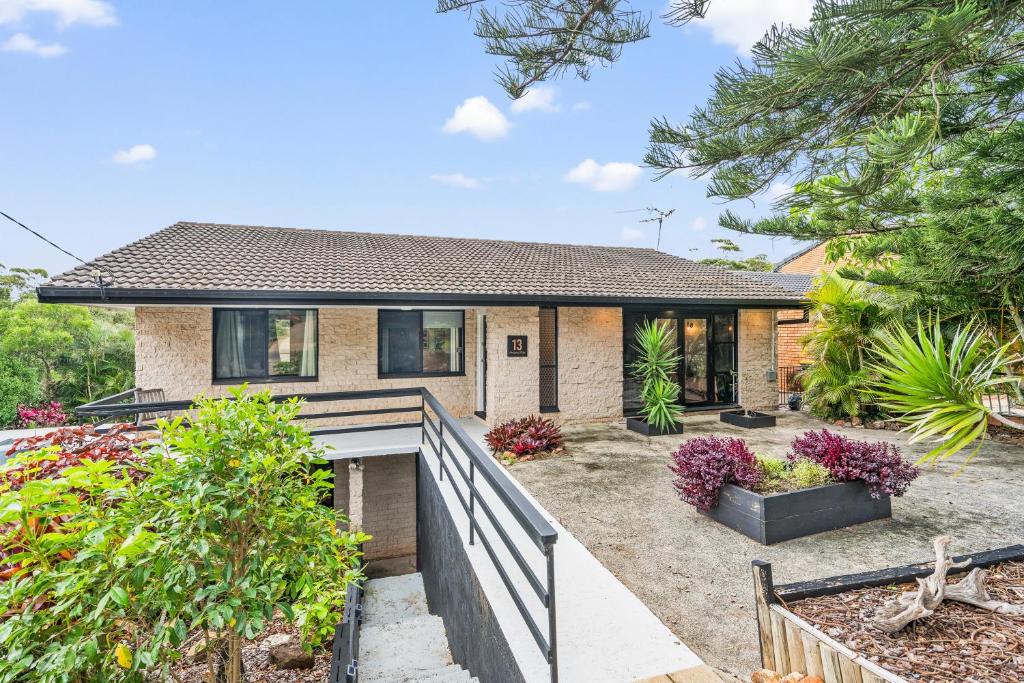 a house with a fence in front of it at 13 AMAROO in Port Macquarie