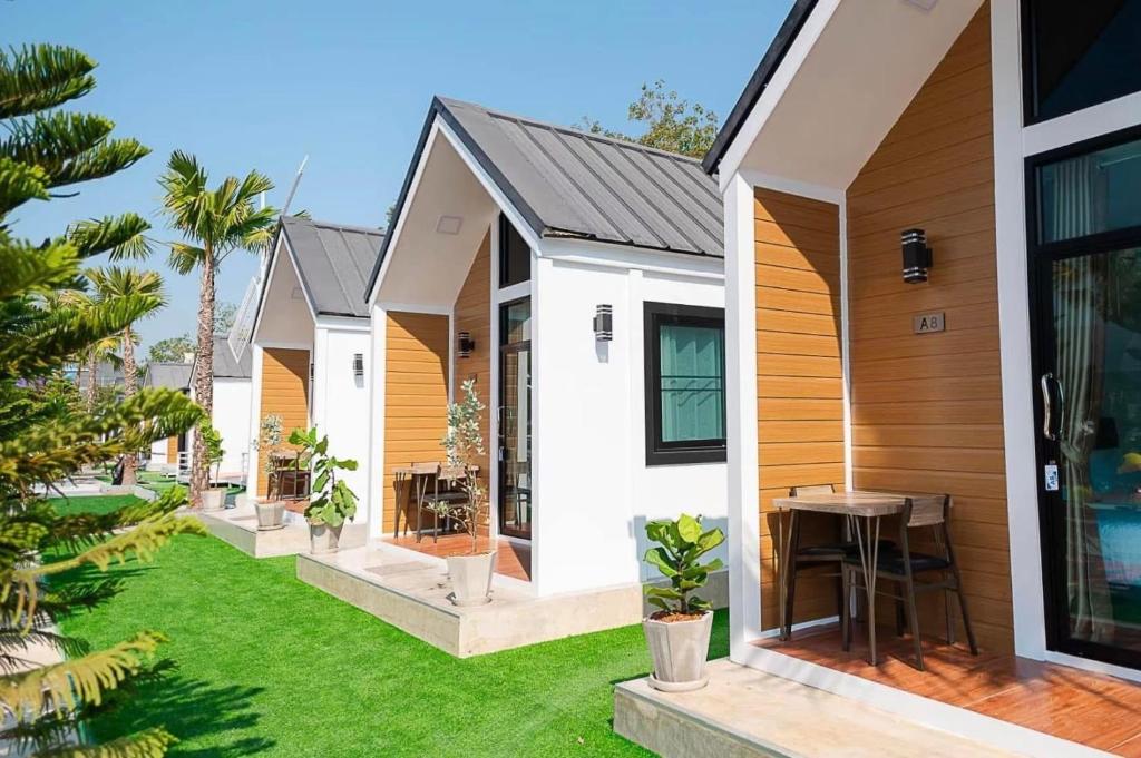 a row of cottages with a green yard at Air diamond resort in Ban Nong Bon