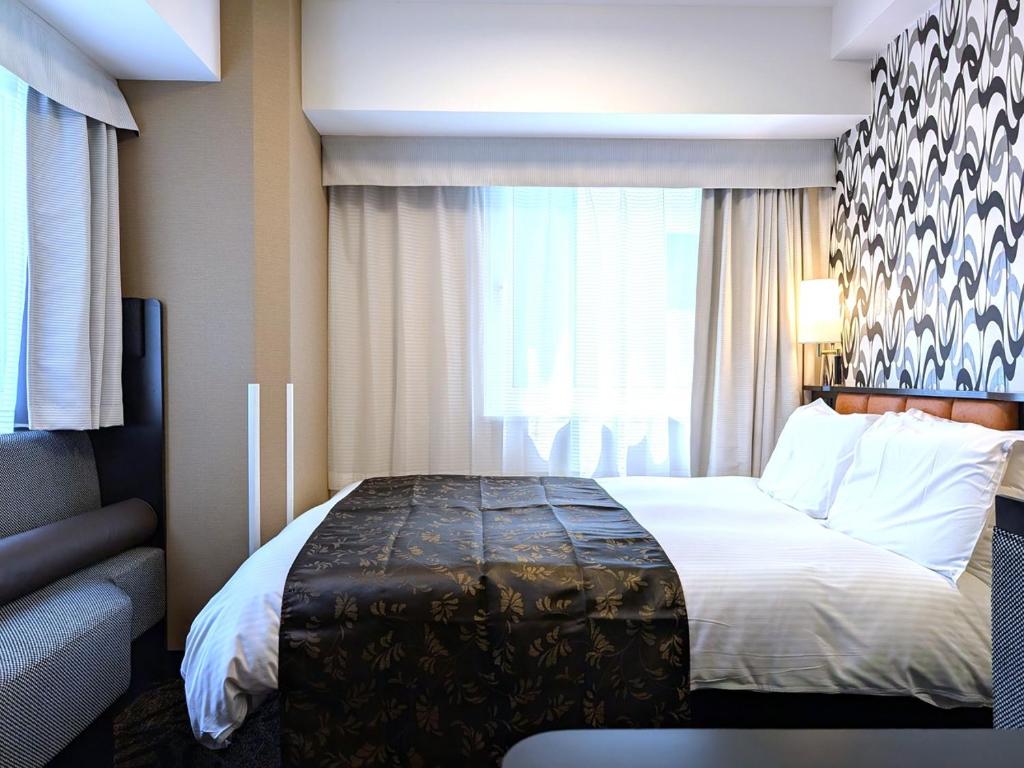 Postel nebo postele na pokoji v ubytování APA Hotel Nihombashi Bakuroyokoyama Ekimae