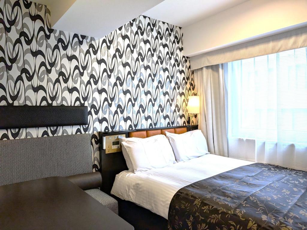 Postel nebo postele na pokoji v ubytování APA Hotel Nihombashi Bakuroyokoyama Ekimae