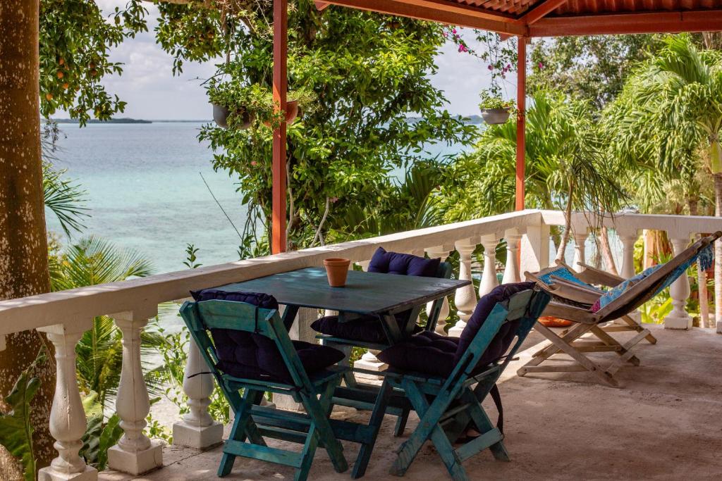 una mesa y sillas en un porche con vistas al océano en Dog Friendly Villas Pehaltun Bacalar, en Bacalar
