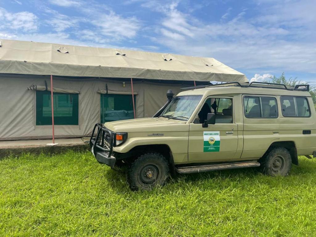 une jeep garée devant une tente dans l'établissement AMENITY TOURs & CAMPING - SERENGETI, à Lukungu