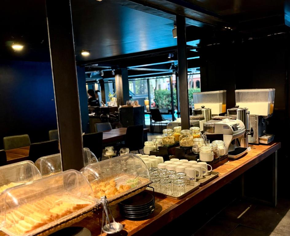 A covered breakfast buffet with pastries, cereals, drinks and coffee equipment.