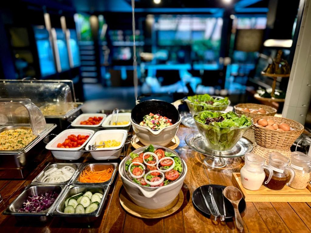 A close-up breakfast spread focused on salads, vegetables, eggs and toppings.