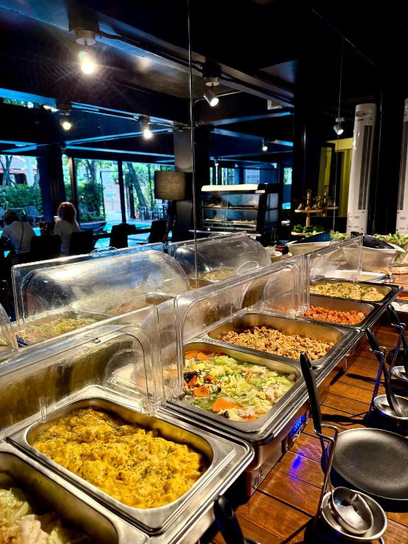 A buffet line with covered hot dishes and a view into the breakfast room.