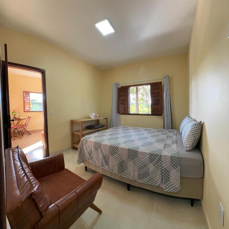 a bedroom with a bed and a couch and a chair at Chalés Refúgio da Sil 2 in Cavalcante