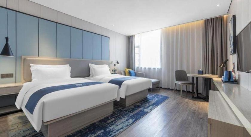 Postel nebo postele na pokoji v ubytování Echarm Hotel Jiayulongwan Peninsula