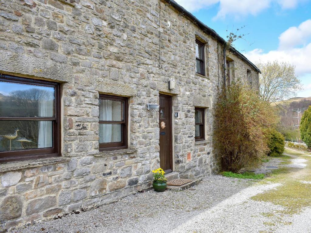 a stone building with a door and a potted plant at 2 Swallowholm Cottages in Richmond