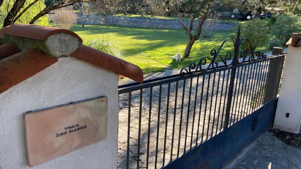 une clôture avec un portail en fer avec un parc derrière dans l'établissement Villa San Marco chambre d hôtes, à Lorgues
