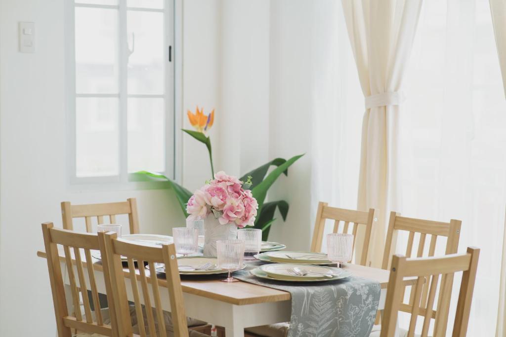 a dining room table with a vase of flowers on it at Villa Serena in Dauis