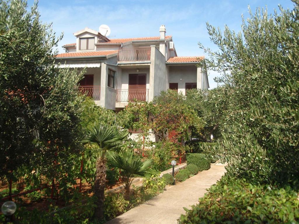 a large house with a pathway in front of it at Apartments Ukić in Tribunj