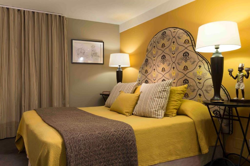 ein Hotelzimmer mit einem Bett mit einem großen Kopfteil in der Unterkunft Hotel De France in Angerville