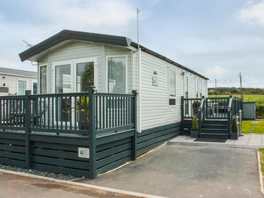 a mobile home with a porch and a fence at Long View Lodge in Felton