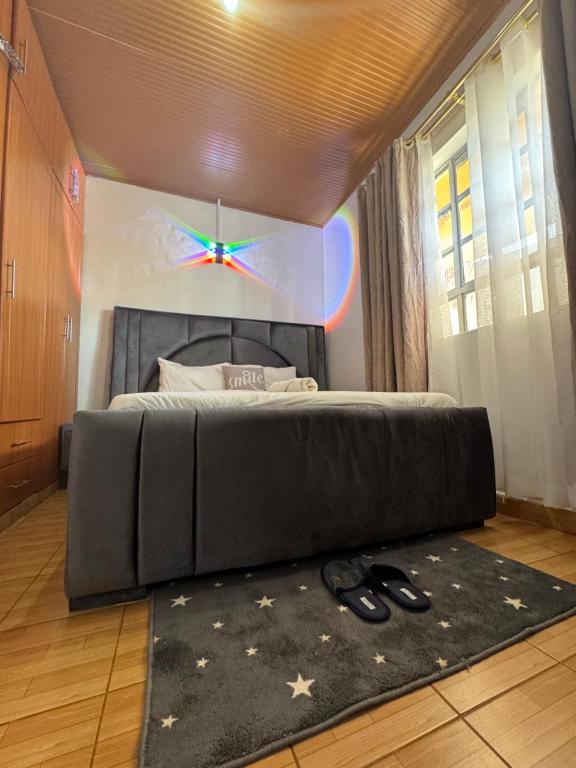 a bedroom with a black bed with a star on the wall at Eldoret Hideout Cozy 1-Bed Along Kisumu Road Near Tamasha in Eldoret