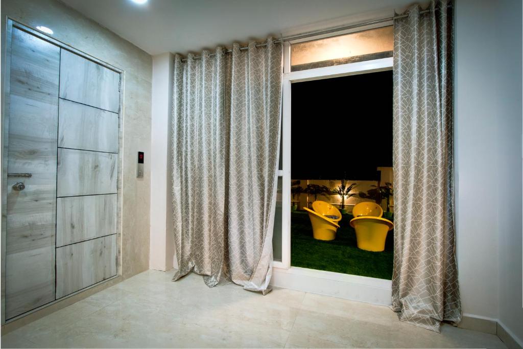a bathroom with a large window with a view of a yard at The Sunbird in Kondapur