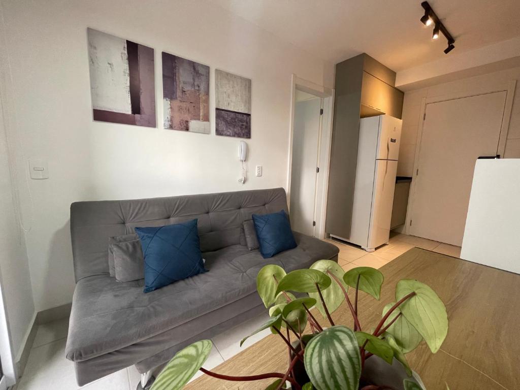 a living room with a gray couch and blue pillows at Apto Completo na Chac Sto Antonio 7 min do Vibra SP in Sao Paulo
