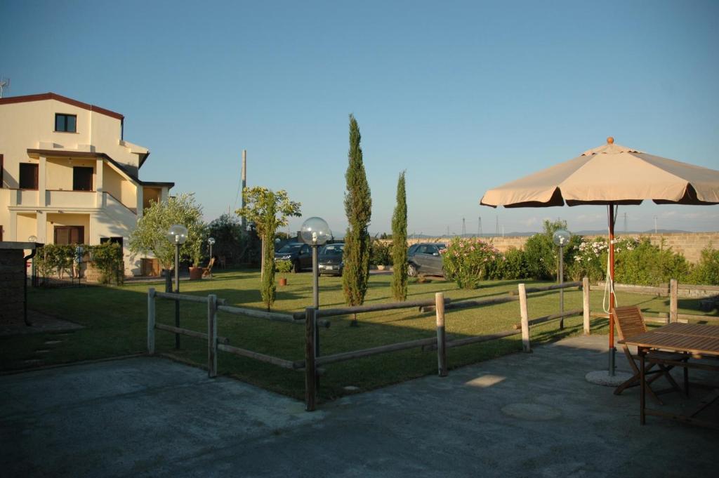 a park with a fence and an umbrella and a table at Villa Althea in Piombino