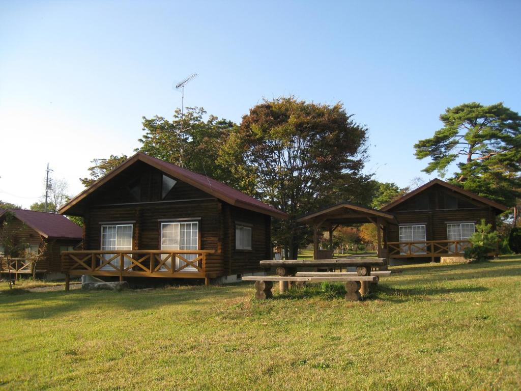 een blokhut met een picknicktafel ervoor bij 神石高原ティアガルテン 