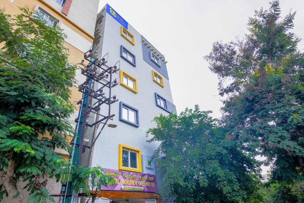 a white building with yellow windows on the side of it at FabExpress Golden Grand Inn - Global Village in Bengaluru