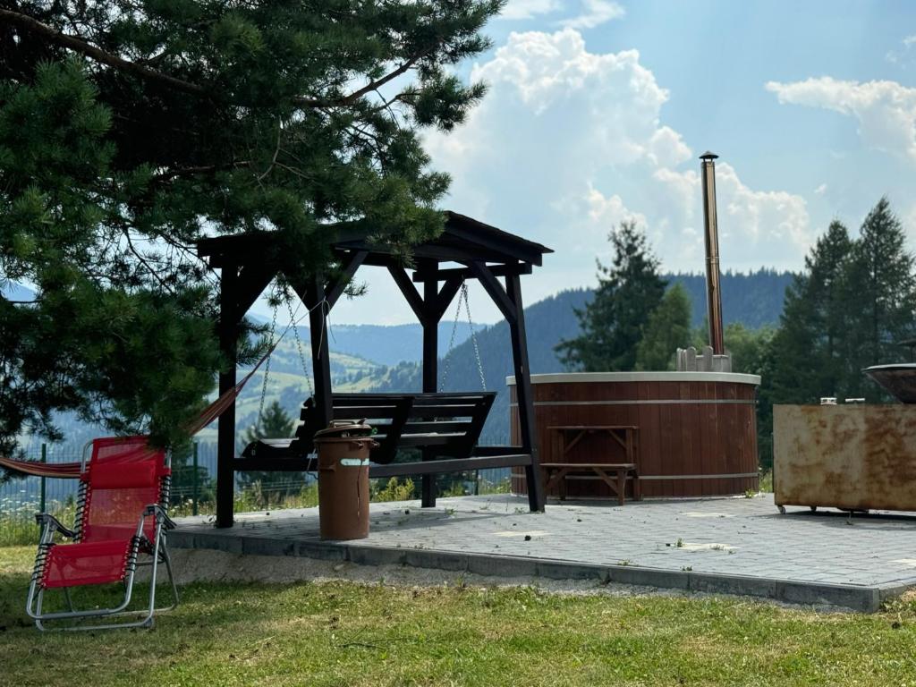 a picnic shelter with a picnic table and a bench at Cabana Colț de Rai Ilva Mare in Ilva Mare